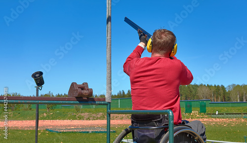 man in wheelchair is practicing skeet shooting, copy space