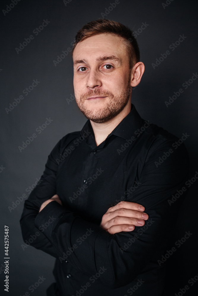 Portrait of a man in a black shirt in a closed pose Portrait of a man in a black shirt in a closed pose