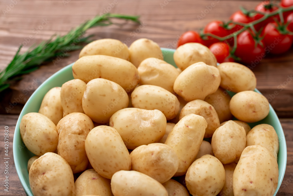 Raw young small potatoes on a wooden background. Raw young small potatoes on a wooden background.