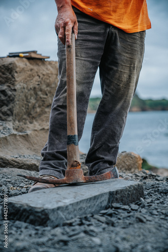 Cancagua stone craftsman, taking a break leaning on his pillory, on the coast of Ancud, Chiloé island. photo