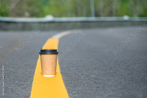 Close-up paper cup of coffee on the road. For a coffee shop