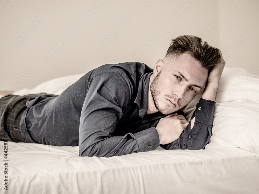 Sexy young man on bed with blue shirt Sexy young man on bed with blue shirt