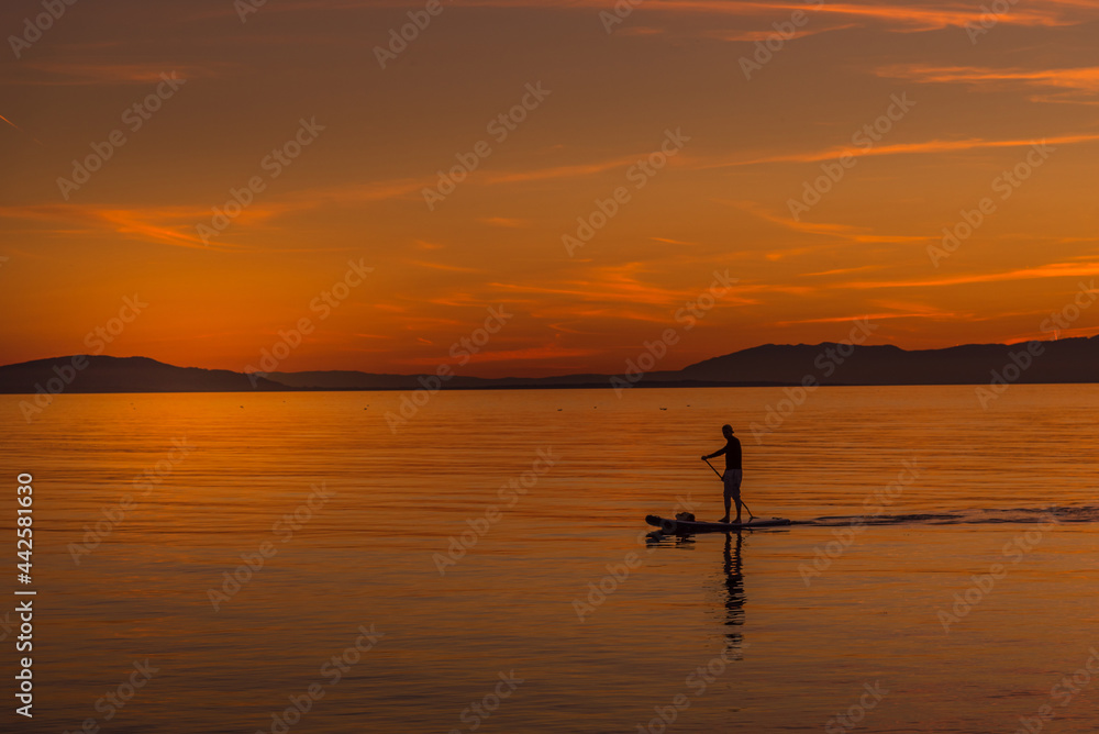 Unrecognized person during beautiful sunset in the coast from a body board table