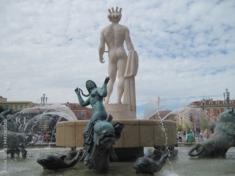 Scenic view of  Fountain of the Sun . The main city square in Nice France is Place Massena.  Famous marble statue of beautiful naked man body.