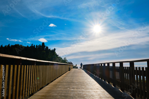 Beautiful sunrise from wooden boardwalk with silhouette of a man walking