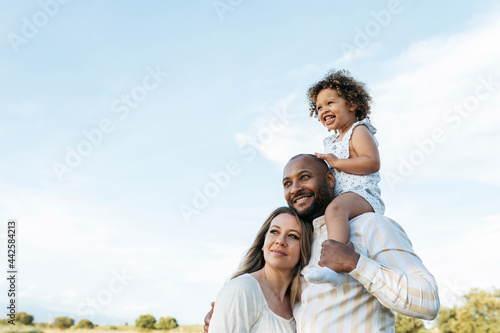 Content multiracial family in summer field