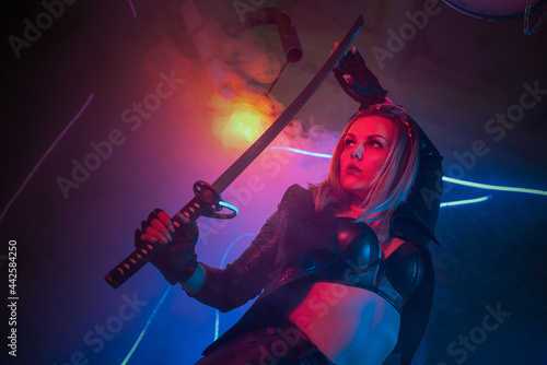 Cyberpunk woman warrior with a katana sword in the neon lights concept. © Dmitriy