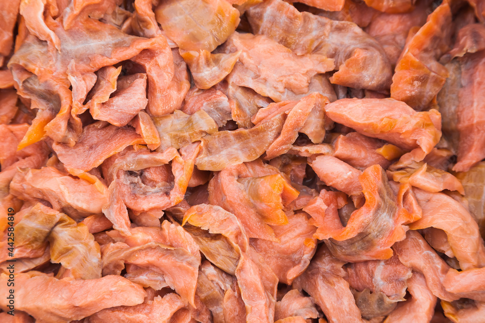 Lots of pieces of salted, finely chopped, red fish, close-up. Lots of pieces of salted, finely chopped, red fish, close-up.