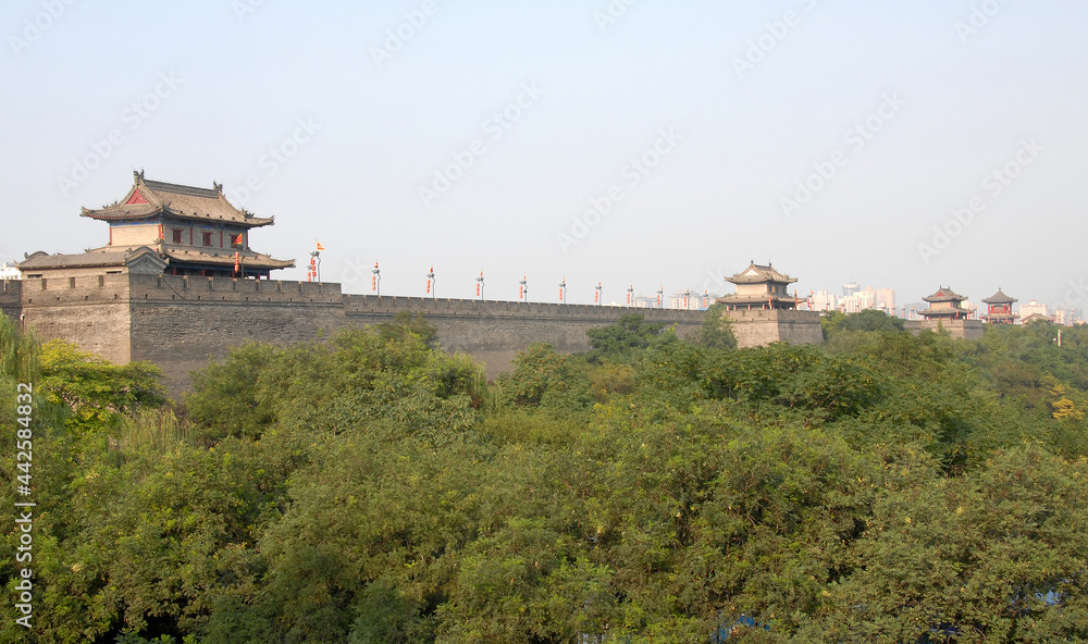City Wall, Xian, Shaanxi Province, China. The City Wall of Xian is one of the largest and best preserved city fortifications in China. Watchtowers on Xian city wall overlooking trees.