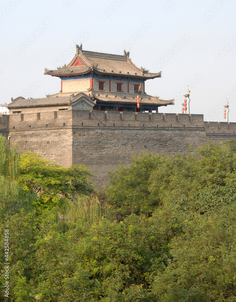Fototapeta premium City Wall, Xian, Shaanxi Province, China. The City Wall of Xian is one of the largest and best preserved city fortifications in China. Watchtower on Xian city wall overlooking trees.