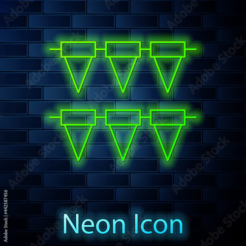 Glowing neon line Carnival garland with flags icon isolated on brick wall background. Party pennants for birthday celebration, festival decoration. Vector