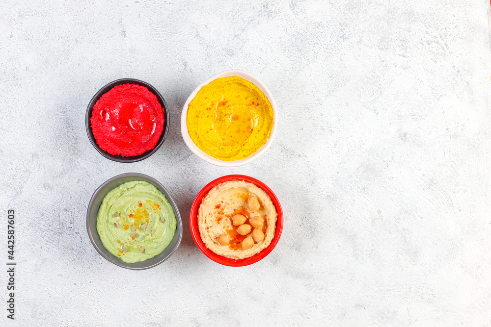 Traditional Middle eastern food various hummus. Green,yellow,beet and traditional hummus in small bowls. Traditional Middle eastern food various hummus. Green,yellow,beet and traditional hummus in small bowls.