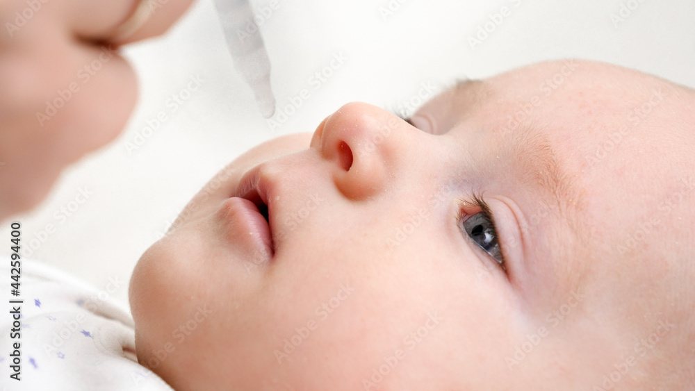 Giving vaccine or vitamins to baby from eyedropper. Concept of newborn babies healthcare and vaccination Giving vaccine or vitamins to baby from eyedropper. Concept of newborn babies healthcare and vaccination