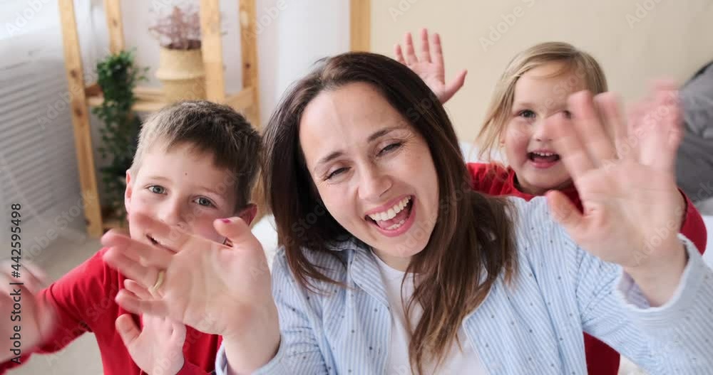 Loving family waving hands looking at camera Loving family waving hands looking at camera