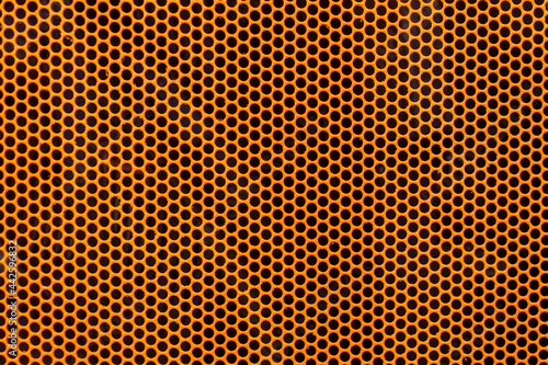 Orange metal texture steel background. Perforated sheet metal.