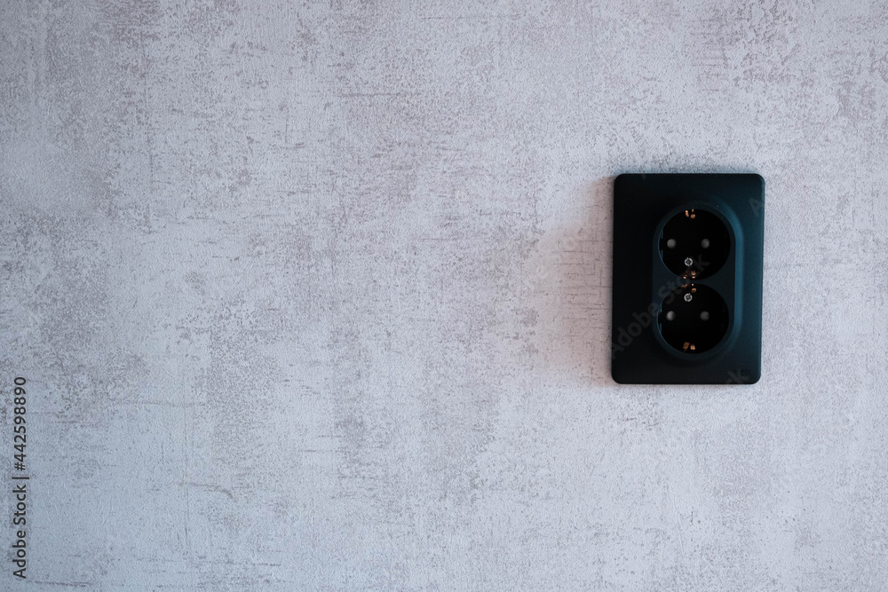 Black socket on a gray wall. Loft. Black socket on a gray wall. Loft.