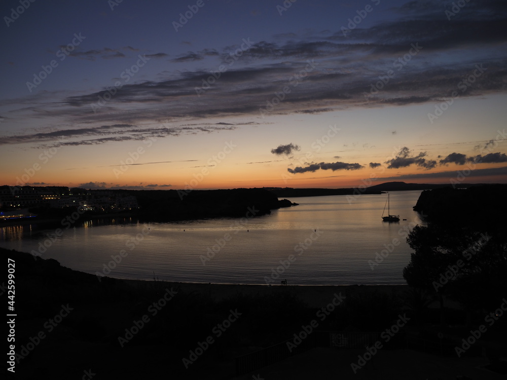 silhouette of a boat in a bay in Menorca