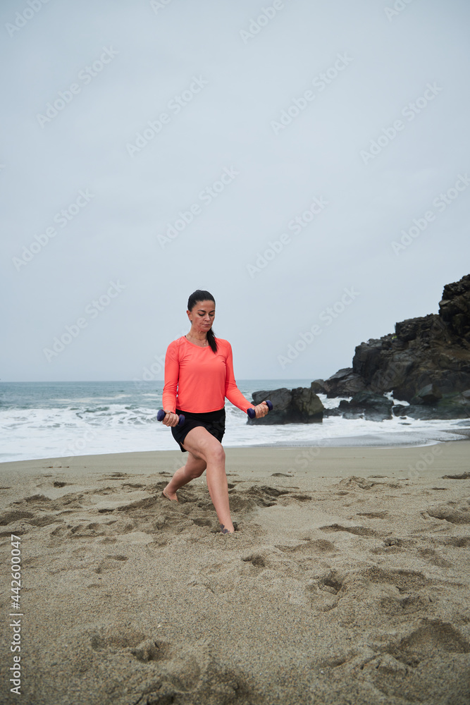 
mature woman practicing yoga and meditation on the beach