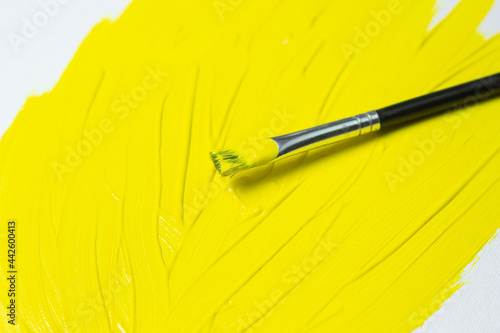 Fototapeta Naklejka Na Ścianę i Meble -  Brush for painting with yellow paint on a yellow background. Watercolor paint