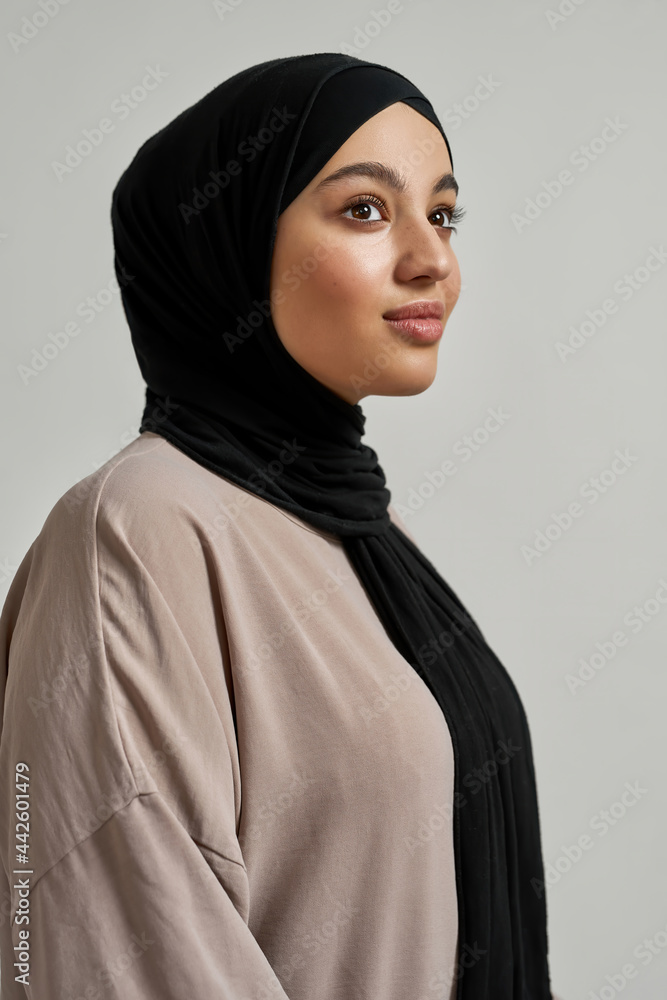 Happy young arabic woman in black hijab posing sideways Stock-Foto | Adobe  Stock
