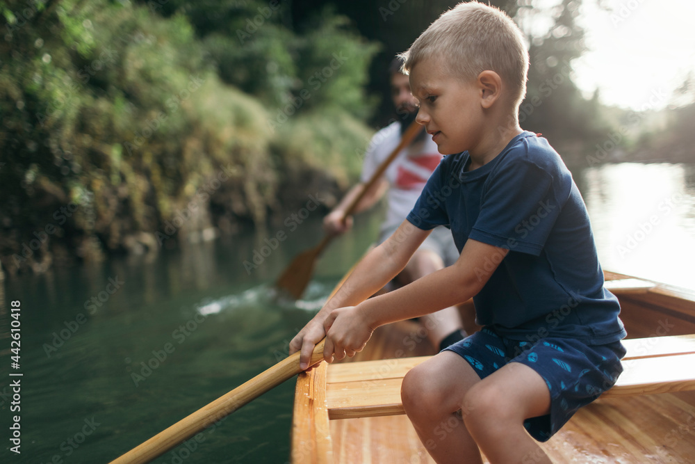 Young boy learn to paddling canoe
