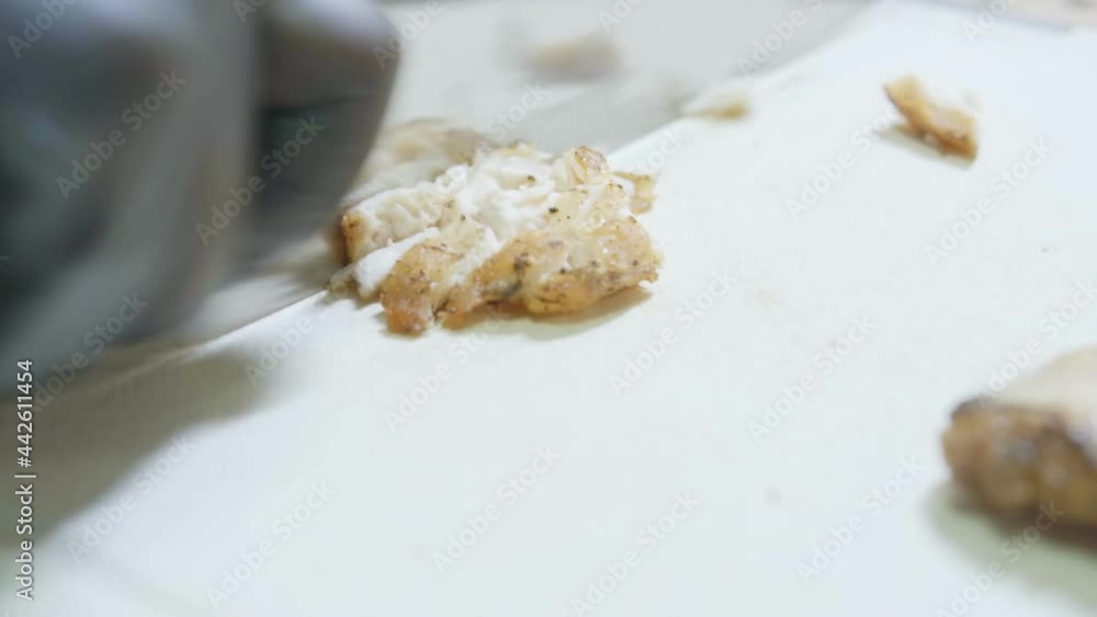 Chef cutting Fried Chicken meat for   cook Cesare salad. Macro shot of cutting chicken meat prepare Caesar salad