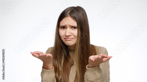 Shocked or dissapointed girl asking what is this with hand gesture over white studio background. photo