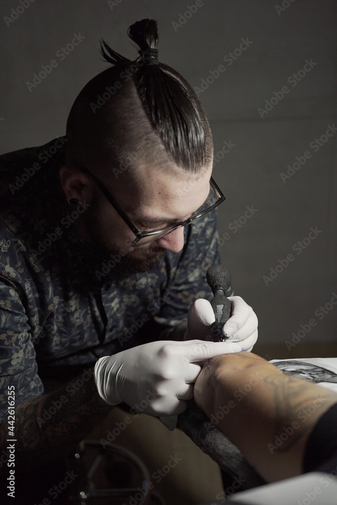Master making tattoo on skin of client Master making tattoo on skin of client