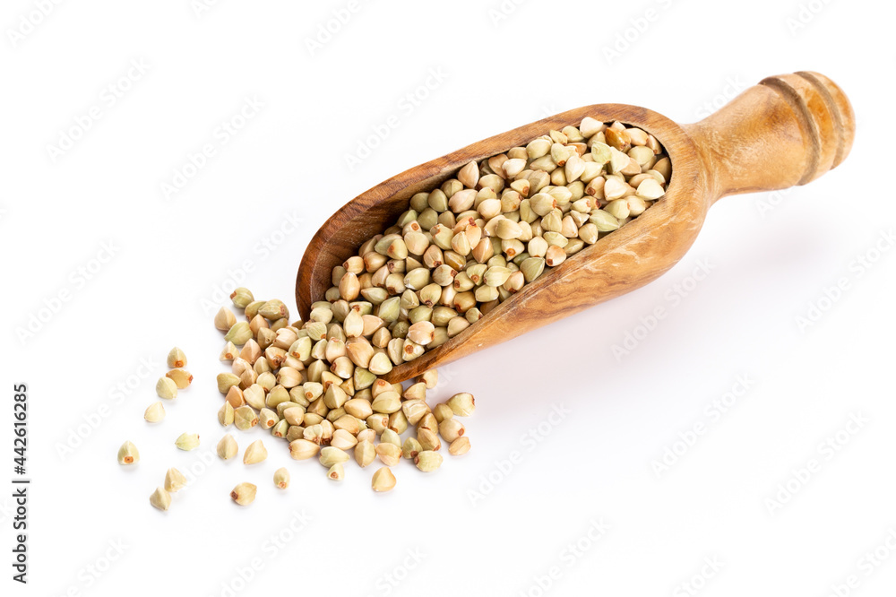 Raw buckwheat and wooden spoon on white background. Raw buckwheat and wooden spoon on white background.