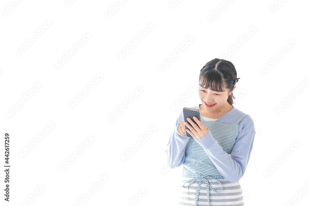 笑顔でスマートフォンを使う若い主婦