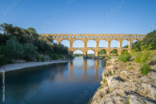 Roman aquaduct Pont du Gard at golden hour with calm river near Avignon, France photo