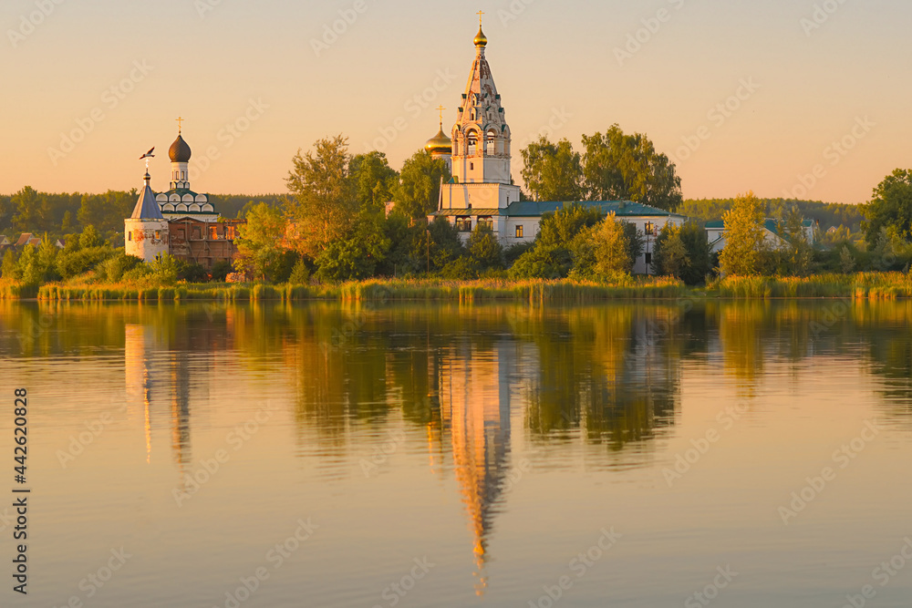 Sunset on the lake. Monastery with reflection in water