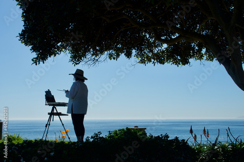 silhouette of landscape painter at sunset
