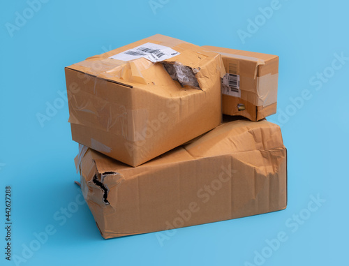 Canvastavla Damaged cardboard box with hole on blue background,cardboard box destroyed in sh
