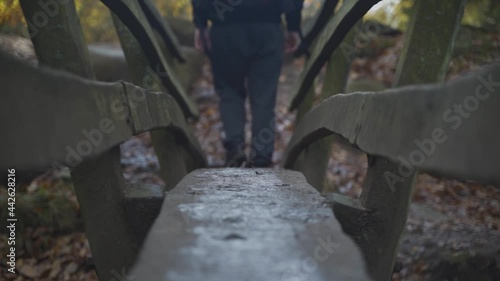 Static shot of person walking on the small bridge in Padley Gorge forest, United Kingdome photo