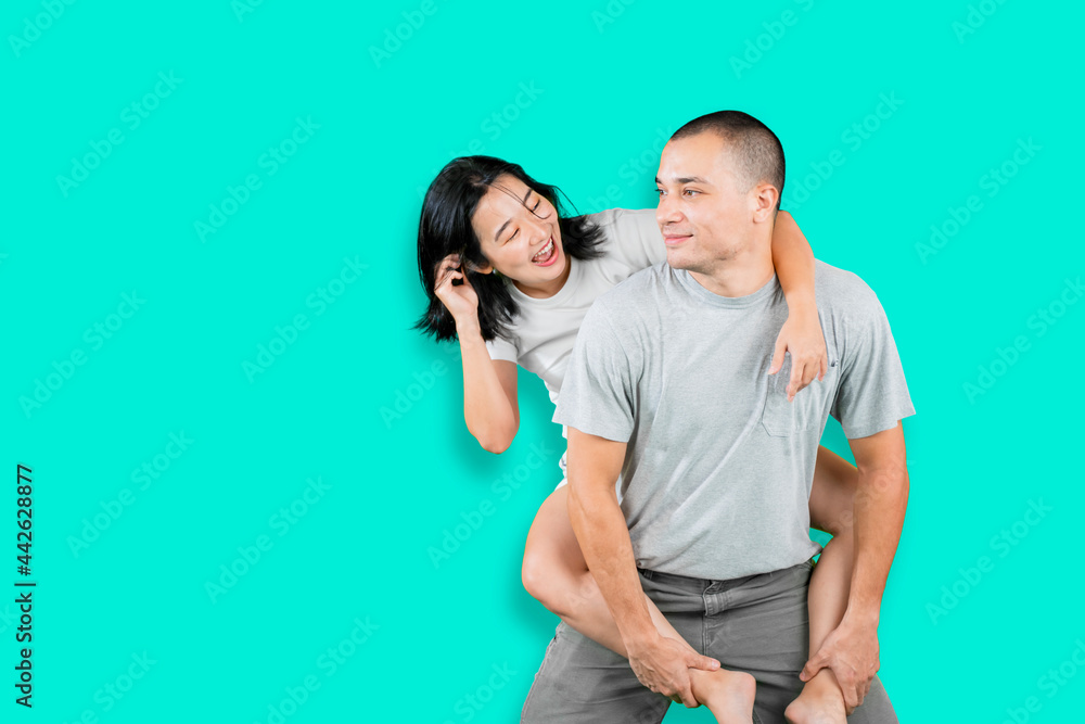 Man giving his girlfriend piggyback ride on studio Man giving his girlfriend piggyback ride on studio
