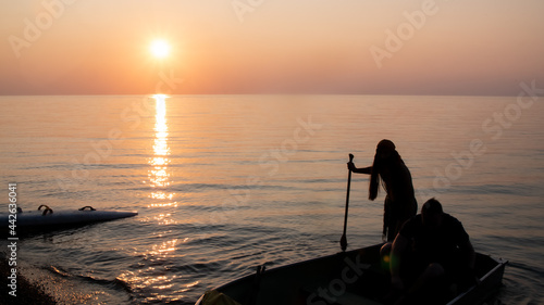 Silhouette of a pirate on the boat sailing into the lake at sunset time in Ontario, Canada.