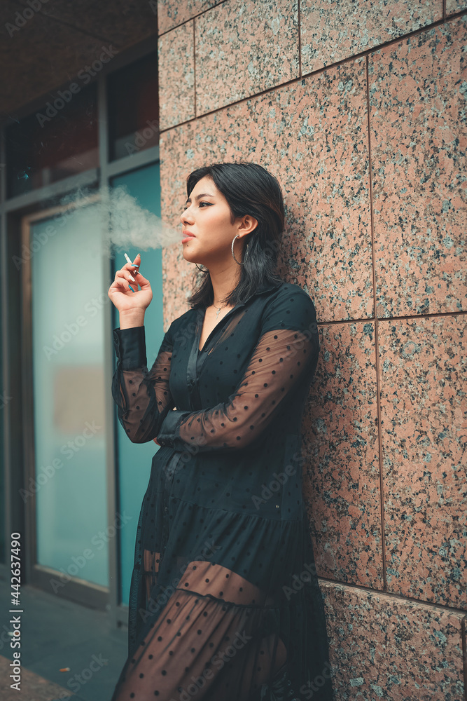 Obraz premium woman wearing a black dress smoking