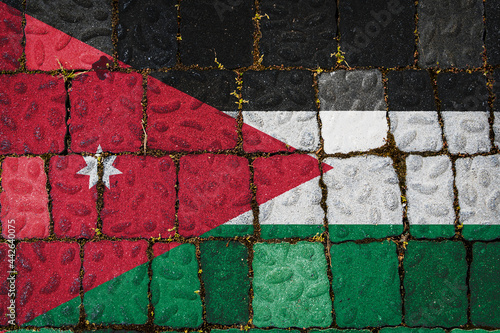 National flag of Jordan on stone wall background. Flag banner on stone texture background.