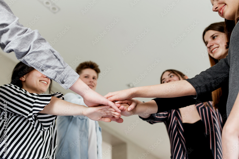 Obraz premium Group of people doing handshake and cross hands