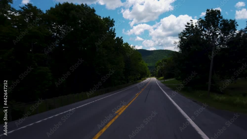 Driving on the empty highway during a sunny day on a local road in the Catskill Mountains, New York Driving on the empty highway during a sunny day on a local road in the Catskill Mountains, New York