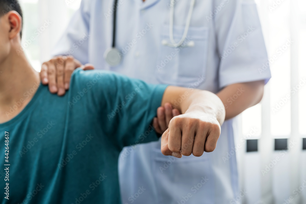 Man physiotherapist stretching shoulder and arm patient at a clinic. Man physiotherapist stretching shoulder and arm patient at a clinic.