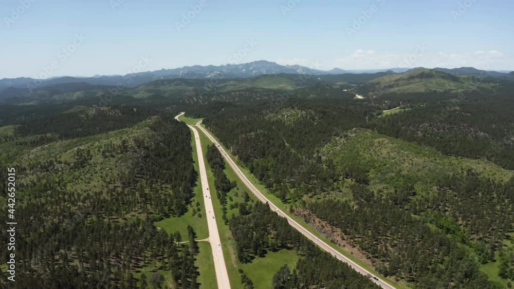 Aerial above forest and roads heading to Mount Rushmore National Memorial on horizon, sunny day, South Dakota Aerial above forest and roads heading to Mount Rushmore National Memorial on horizon, sunny day, South Dakota