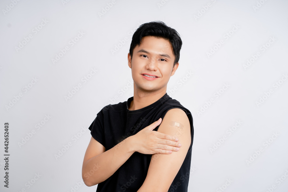 Obraz premium Asian handsome young man receiving coronavirus vaccine on white background He was smiling and happy with the results.