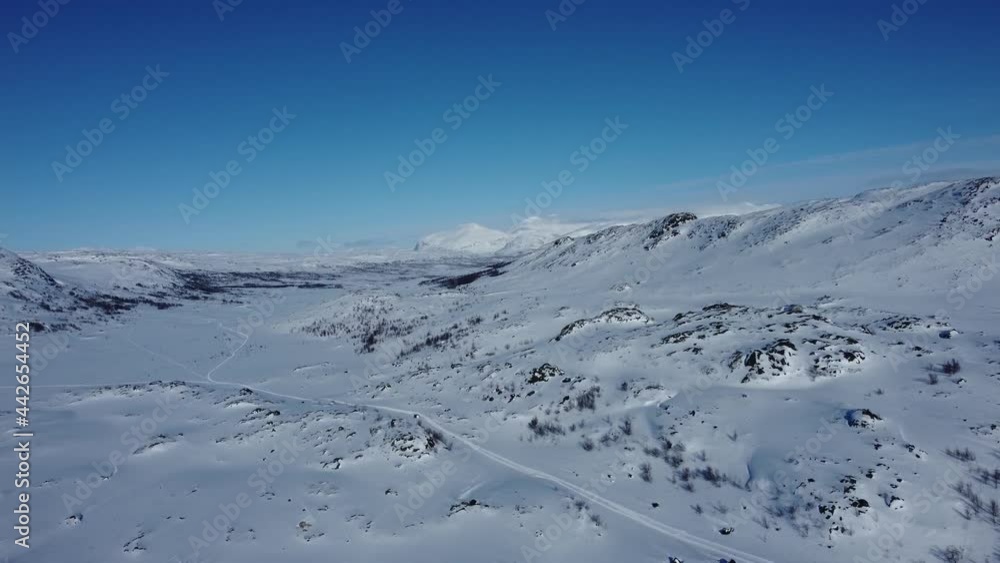 Aerial view of a vast uninhabitable empty snow covered landscape with mountains Aerial view of a vast uninhabitable empty snow covered landscape with mountains