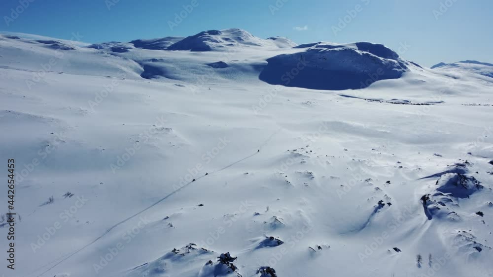 Beautiful aerial shot tracking several snowmobiles on a vast winter landscape Beautiful aerial shot tracking several snowmobiles on a vast winter landscape