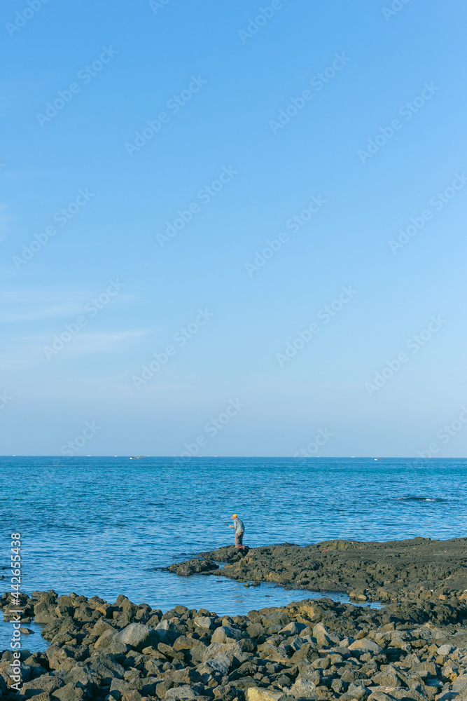 blue sky and ocean with fishing man