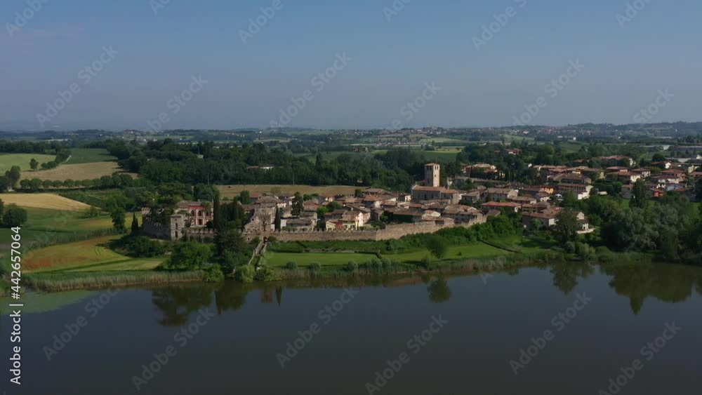Flight point of interest view of Castellaro Lagusello castle on Lagusello lake. Classic Italian medieval villa VILLA TACOLI ARRIGHI, Italy. Flight point of interest view of Castellaro Lagusello castle on Lagusello lake. Classic Italian medieval villa VILLA TACOLI ARRIGHI, Italy.