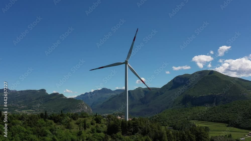 Wind generators in the mountains of Italy. Wind turbine in Affi, Lake Garda. Windmill surrounded by olive trees, vineyards, Alps. Wind turbine in Italy. Wind farm in the Alpine nature. Wind generators in the mountains of Italy. Wind turbine in Affi, Lake Garda. Windmill surrounded by olive trees, vineyards, Alps. Wind turbine in Italy. Wind farm in the Alpine nature.