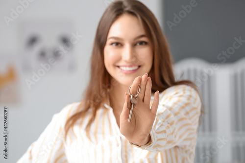 Happy young woman with key ...